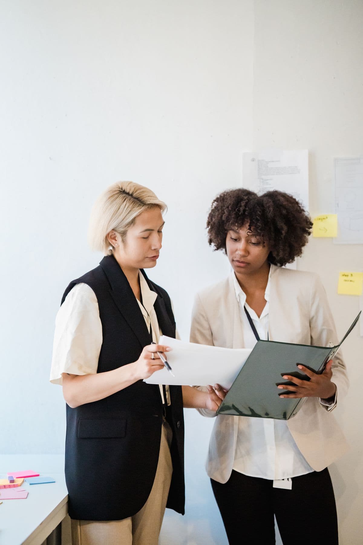 Two colleagues reviewing a compliance document together in an office